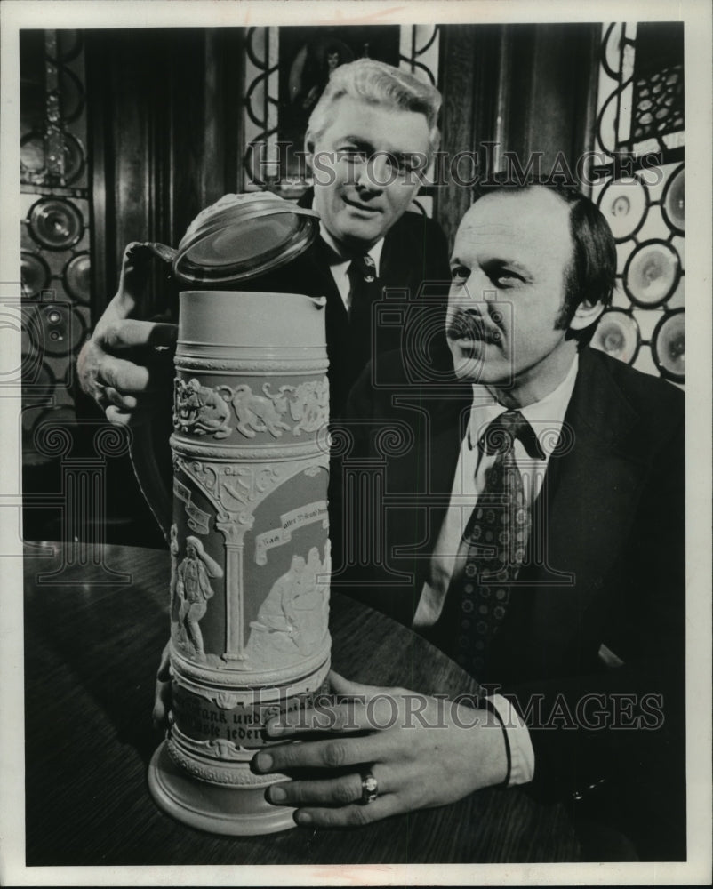 1977 Press Photo Pat Mahoney and Robert Lewinski look at huge German beer stein - Historic Images