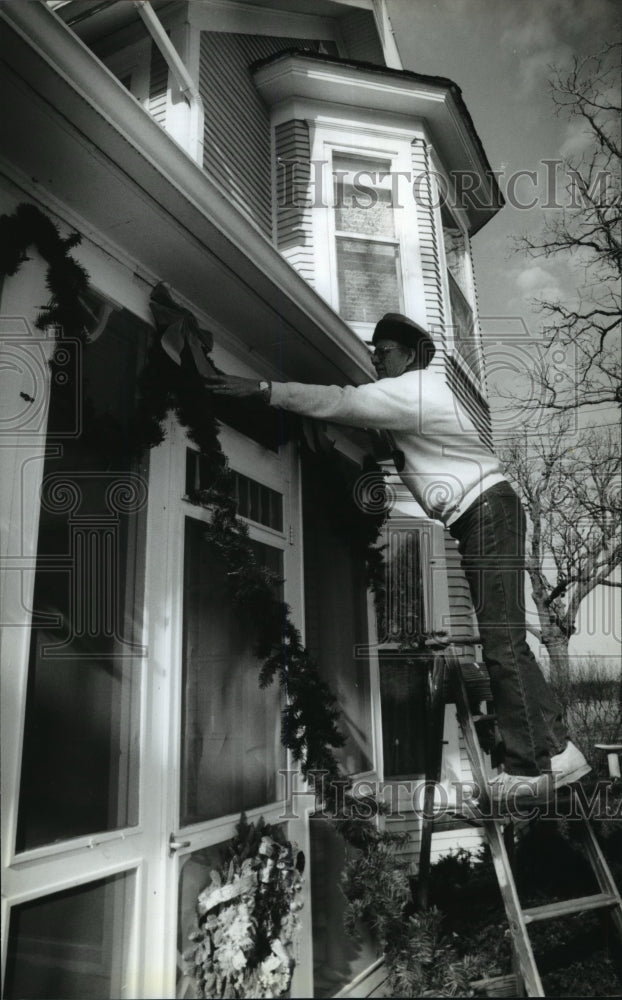 1993 Press Photo Jack Bouche Decorating Exterior of House With Pine Boughs-Historic Images