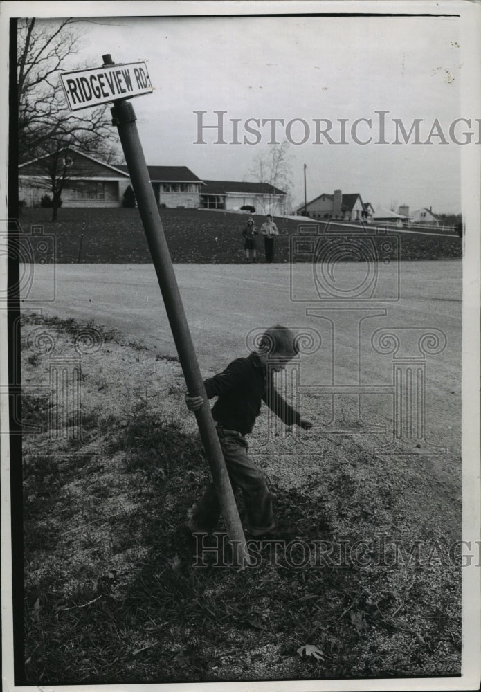 1959 Press Photo Billy Swinging From Sign While Siblings Wait For School Bus - Historic Images