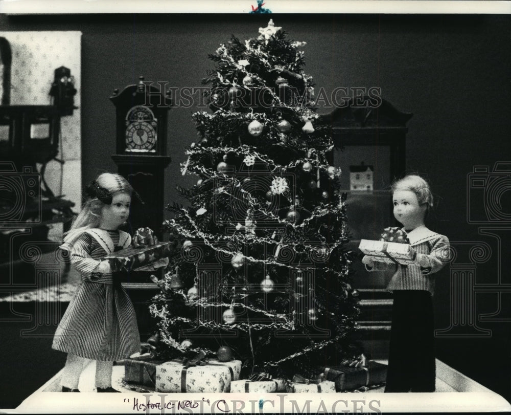 1990 Press Photo Miniature boy and girl sing carols in front of a Christmas tree - Historic Images