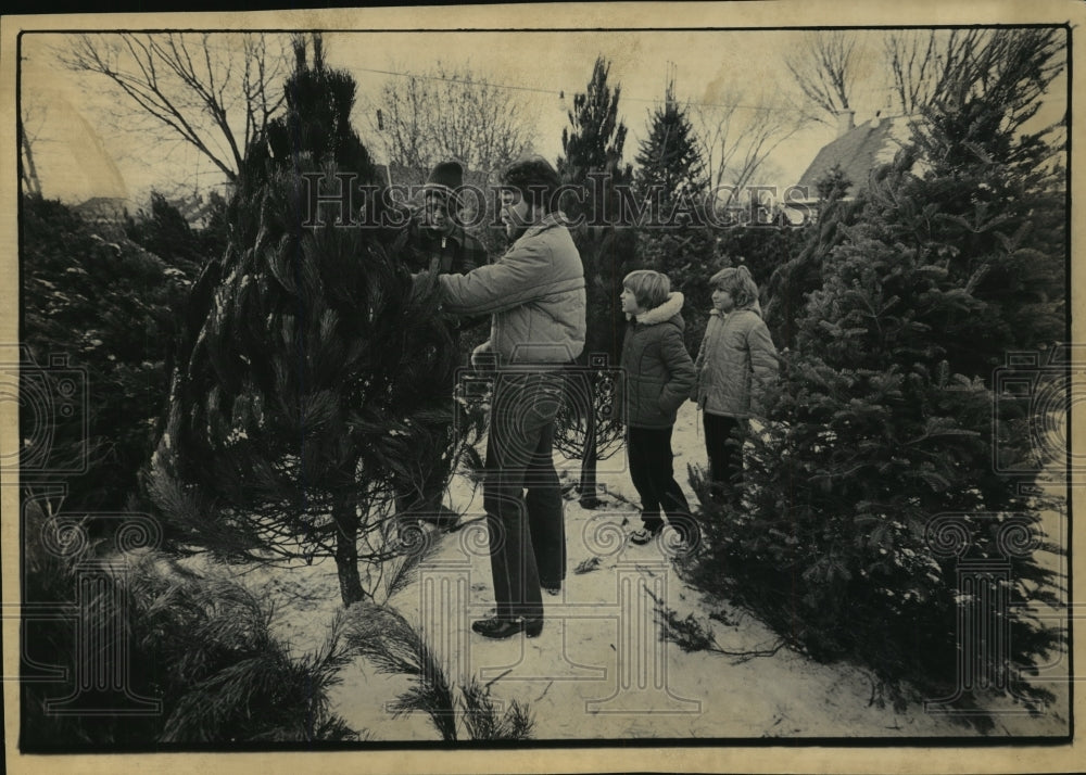 1985 Press Photo Ray Raatz Helps a Family Find a Christmas Tree - Historic Images