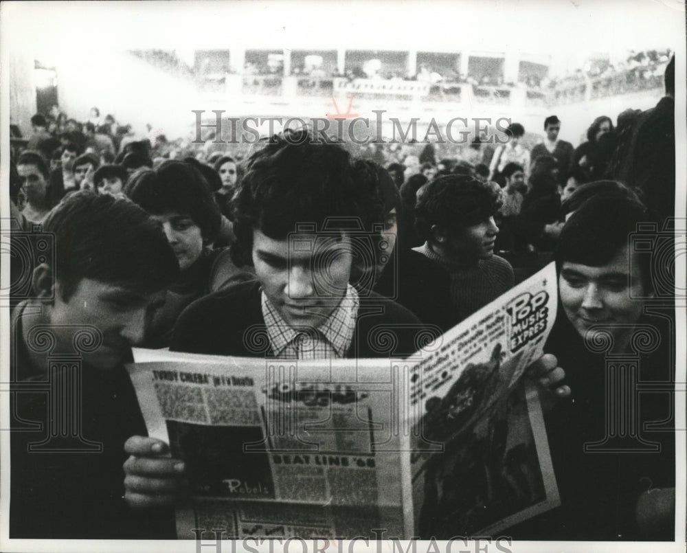 1969 Press Photo Young man reading Pop Music Express while waiting for festival-Historic Images
