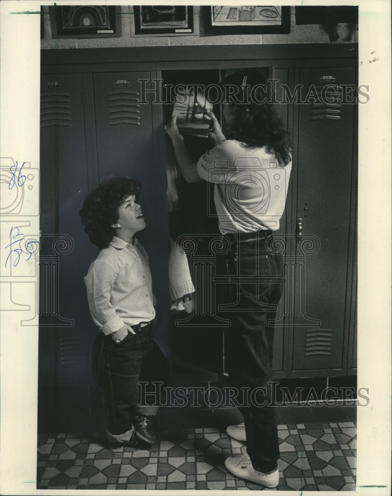 1983 Press Photo Anita Delvalle helped Monica Karpfinger get books on top shelf - Historic Images