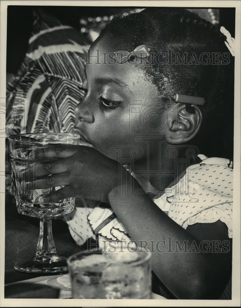 1985 Kanisha Brown sipping from a large glass of water, Cafe Rouge-Historic Images