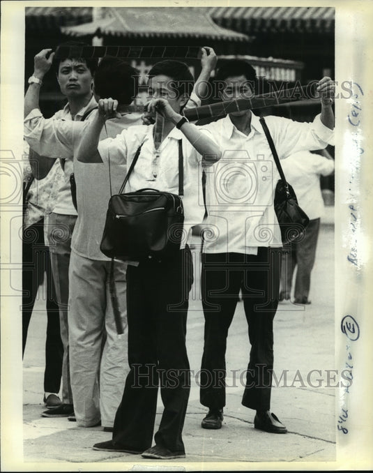 1983 Press Photo Chinese looking at negatives from quick service photo lab-Historic Images