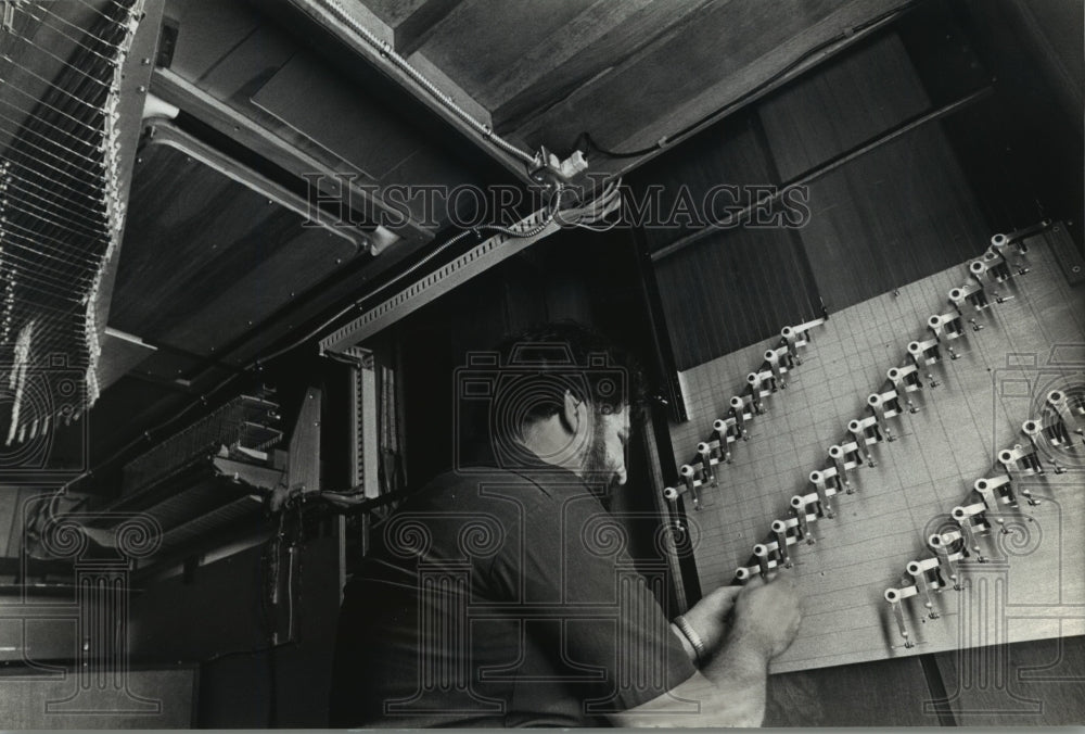 1989 Press Photo Neil Palmer works on wires, Concordia University of Wisconsin - Historic Images