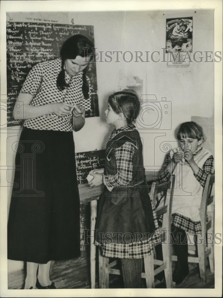 1938 Press Photo a teacher showing a little girl needlecraft - mja80027-Historic Images