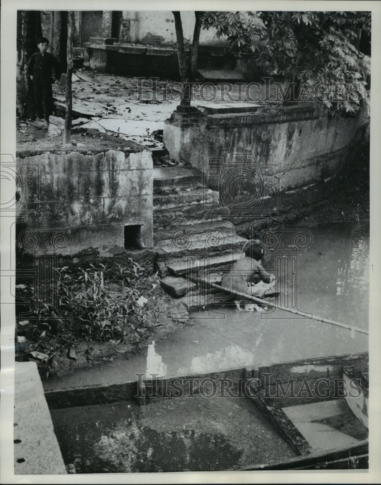 1962 Press Photo a woman does her washing in the river through the commune-Historic Images