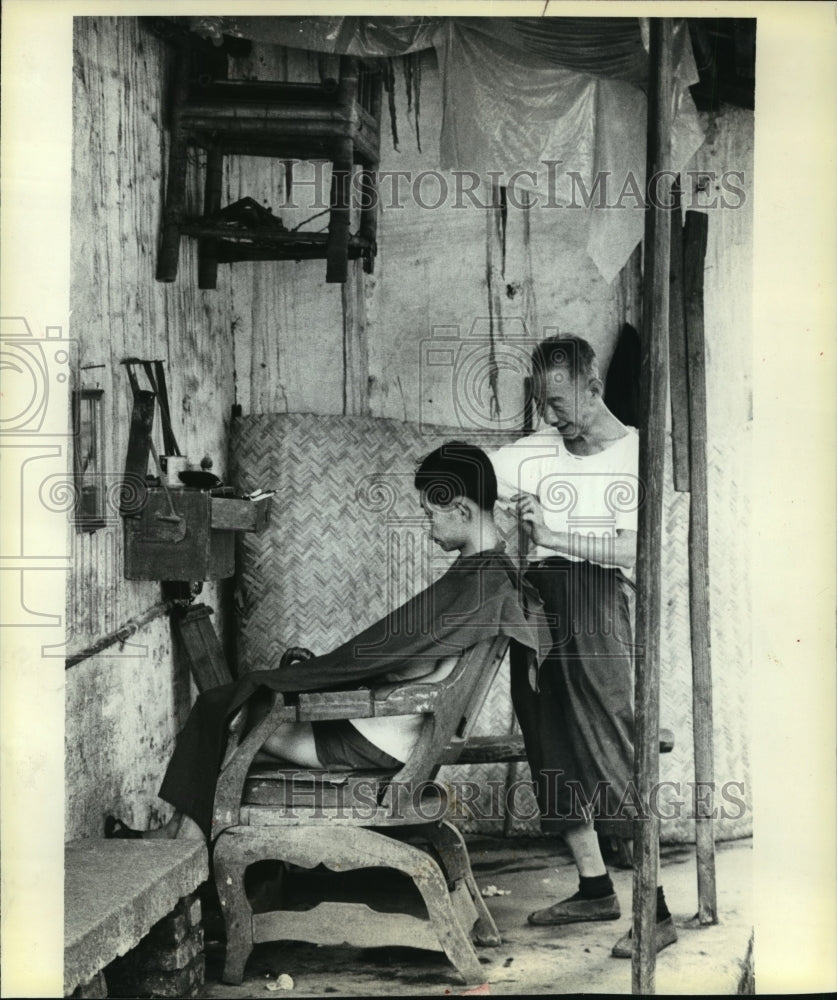 1980 Press Photo barber in Canton, China, using ancient-looking equipment - Historic Images