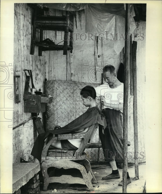 1980 Press Photo barber in Canton, China, using ancient-looking equipment - Historic Images