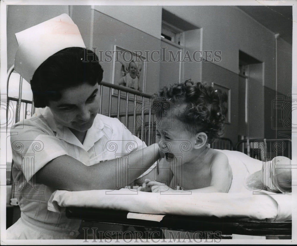 1957 Press Photo Dawn Dzibiuski is consoled by Miss Carol Lang, nurse - Historic Images