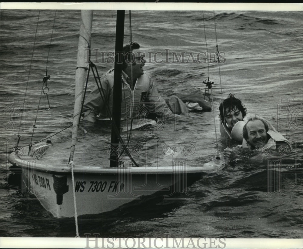 1962 Press Photo Milwaukee Journal sailboat crew getting towed, boat capsized - Historic Images