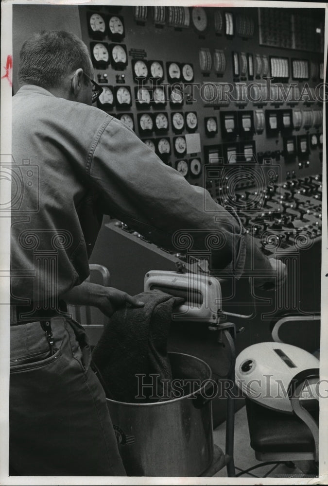 1966 Press Photo employee wrings a towel at the Electric Co.'s Oak Creek plant - Historic Images