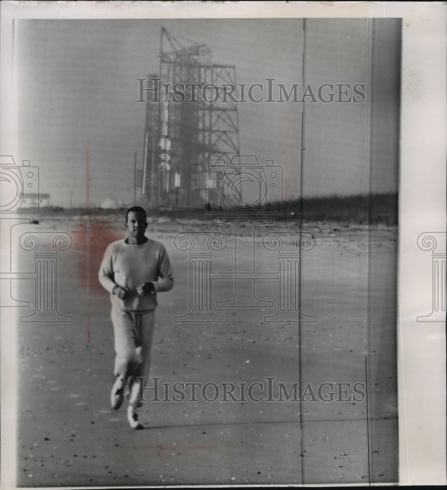 1963 Press Photo Leroy Gordon Cooper jogging by a gantry tower. - mja88542-Historic Images
