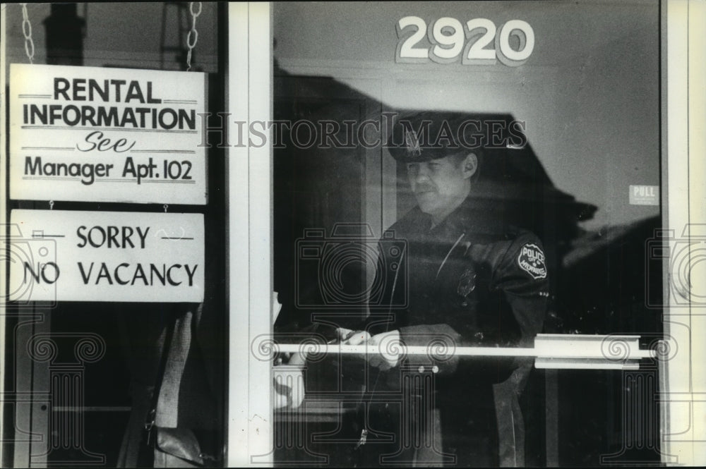 1961 Press Photo Police Officer Talks With Woman at Milwaukee Apartment Building - Historic Images