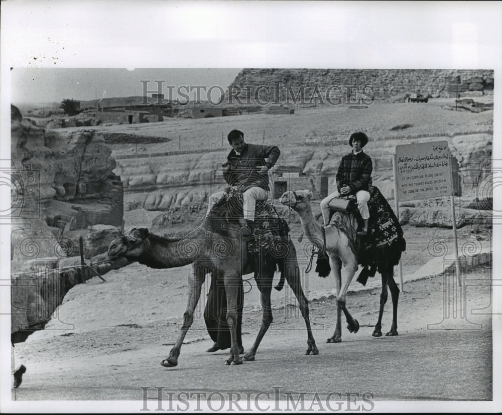 1969 Press Photo Two Tourists Riding Camels Near Cairo Pyramids, Egypt - Historic Images