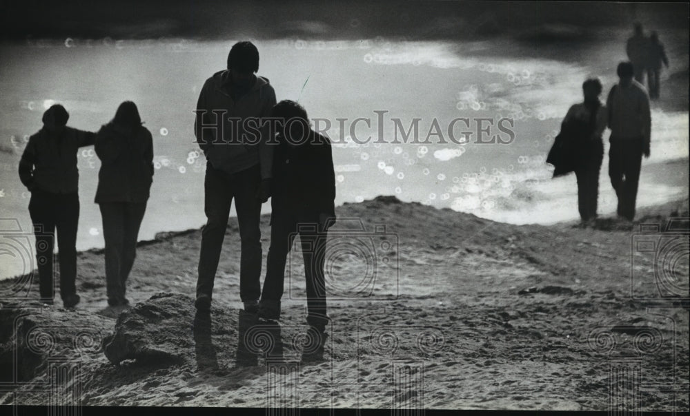 1983 Press Photo Couples are silhouetted as they walk along Bradford Beach - Historic Images