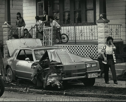 1991 Press Photo Woman looks at a stolen crashed car in Milwaukee, Wisconsin - Historic Images