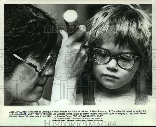1984 Teacher exams deaf students ear at Orallingua School - Historic Images