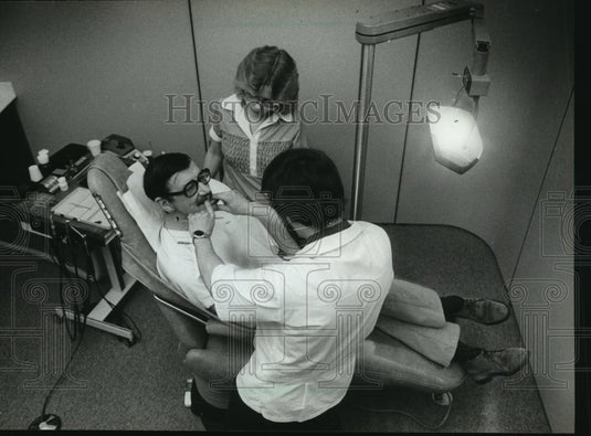 1982 Press Photo James L. Bialk and Cindy Poulsen work on Wally Barth's teeth - Historic Images