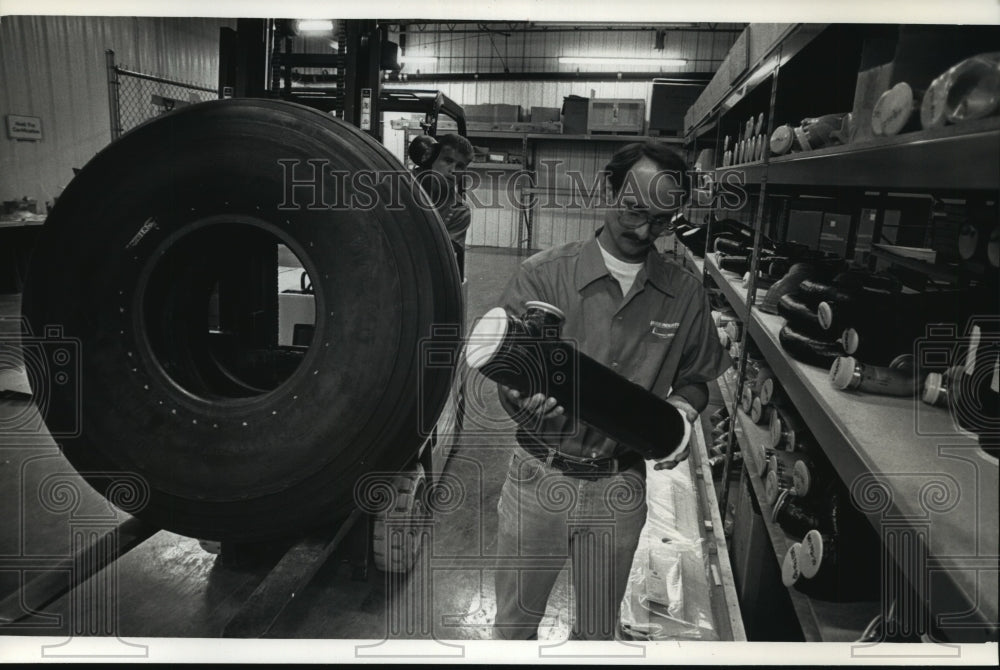 1991 Press Photo Rich Rehberg, John Campbell of Derco Industries moves parts. - Historic Images