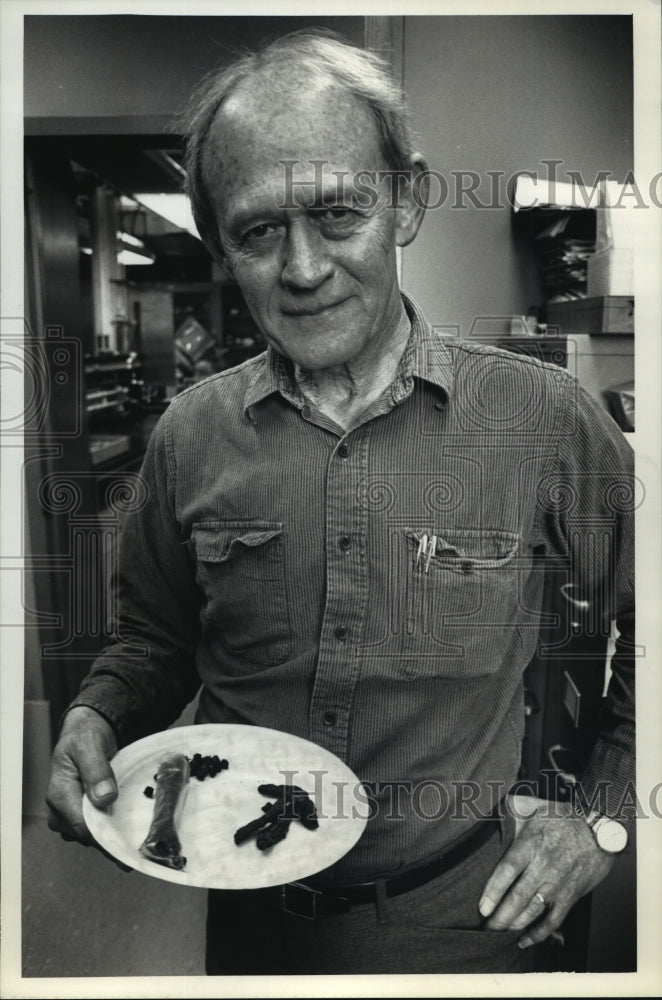 1991 Press Photo Professor Gene R. DeFollart holds a plate of edible insects - Historic Images