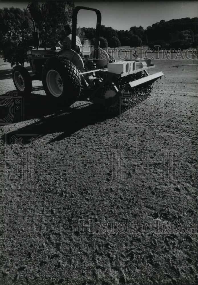 1994 Press Photo Charlie Shaw uses a tractor mounted aerator in Delafield - Historic Images