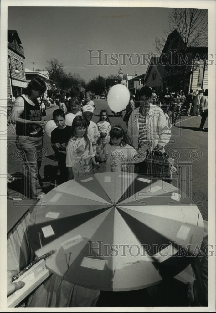 1991 Press Photo Spring festival goers playing wheel of fortune game, Wisconson - Historic Images