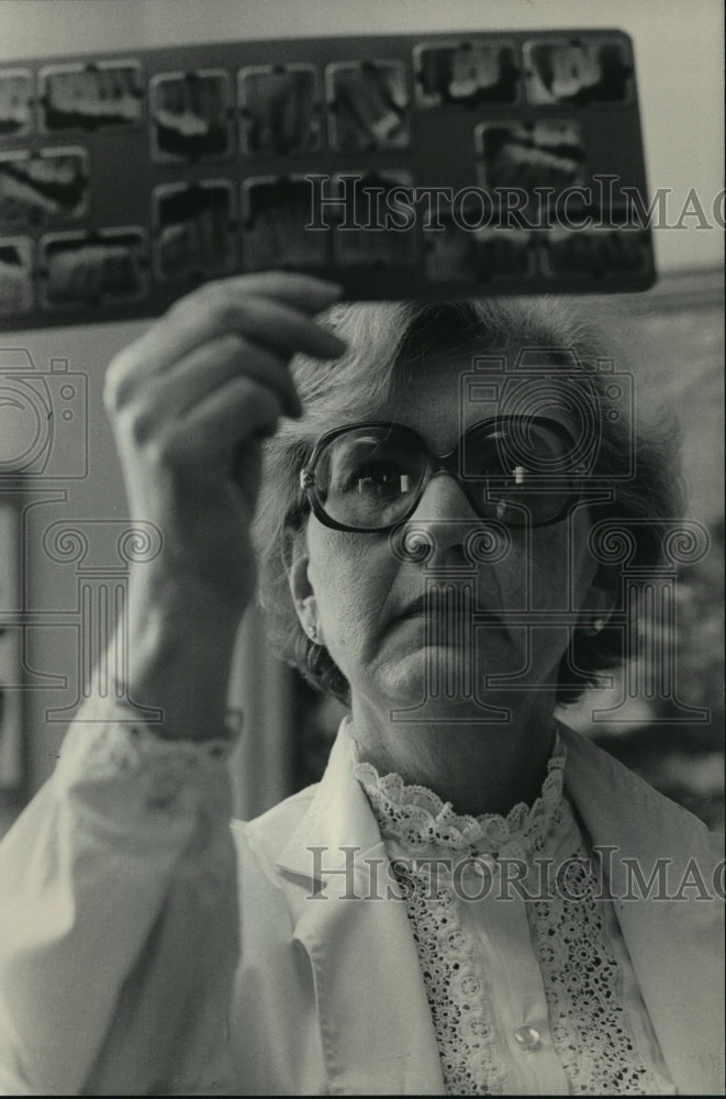 1984 Gloria Adamsons-Schranz examines dental x-rays in Wisconsin - Historic Images