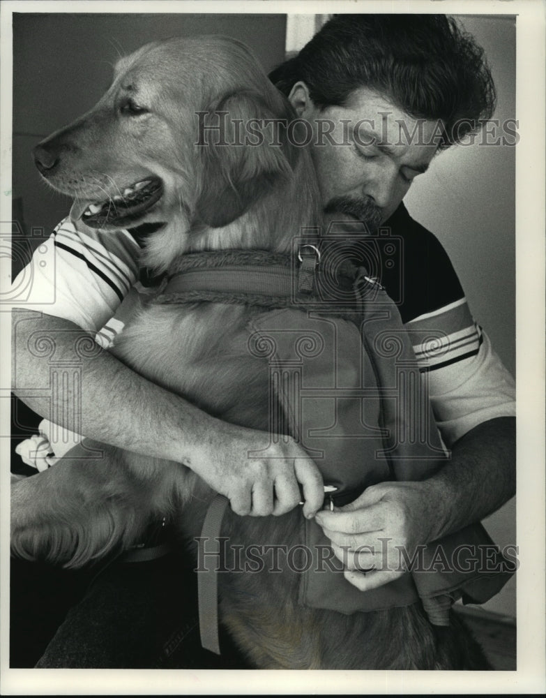 1991 Press Photo Brent Galina put a knapsack on his dog Lincoln before walk - Historic Images