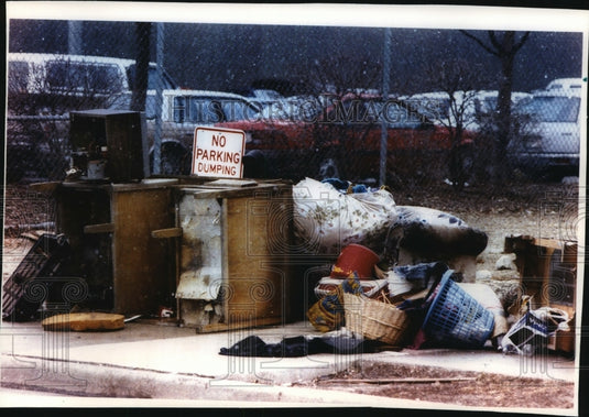 1994 Press Photo Trash is piled along a sidewalk in front of a "No Dumping" sign - Historic Images