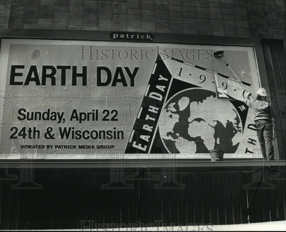 1990 Press Photo Dave Neumann putting up Earth Day billboard Wisconsin - Historic Images