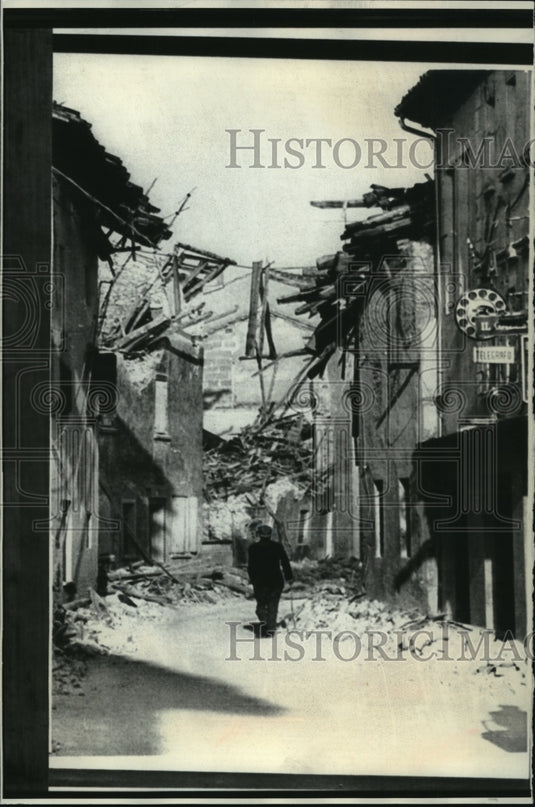 1976 A resident walks through Cassola, Italy after an earthqauke - Historic Images