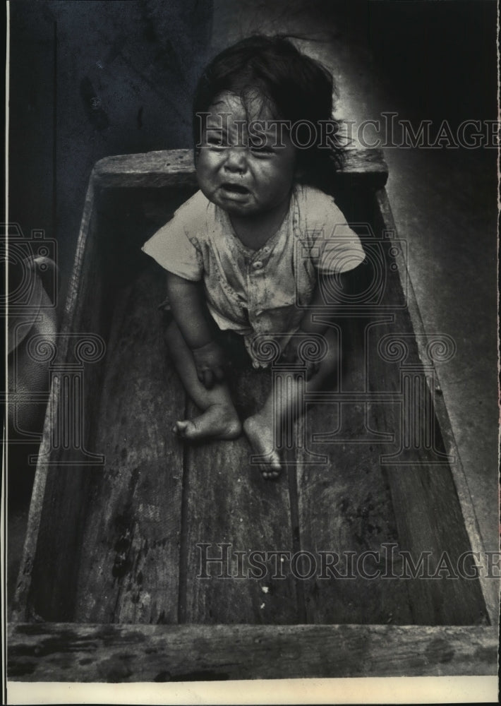 1976 Press Photo An Unhappy Youngster in a Box after Quake in Guatemala City - Historic Images