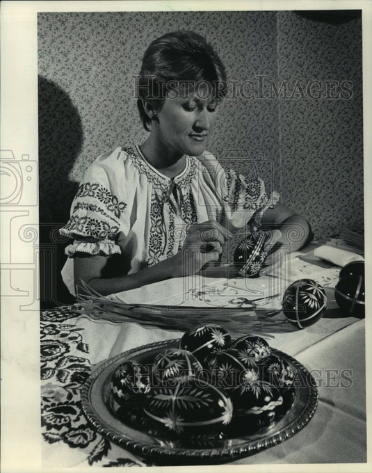 1985 Press Photo Sydney Lee decorating ethnic Easter goose eggs with cut wheat - Historic Images