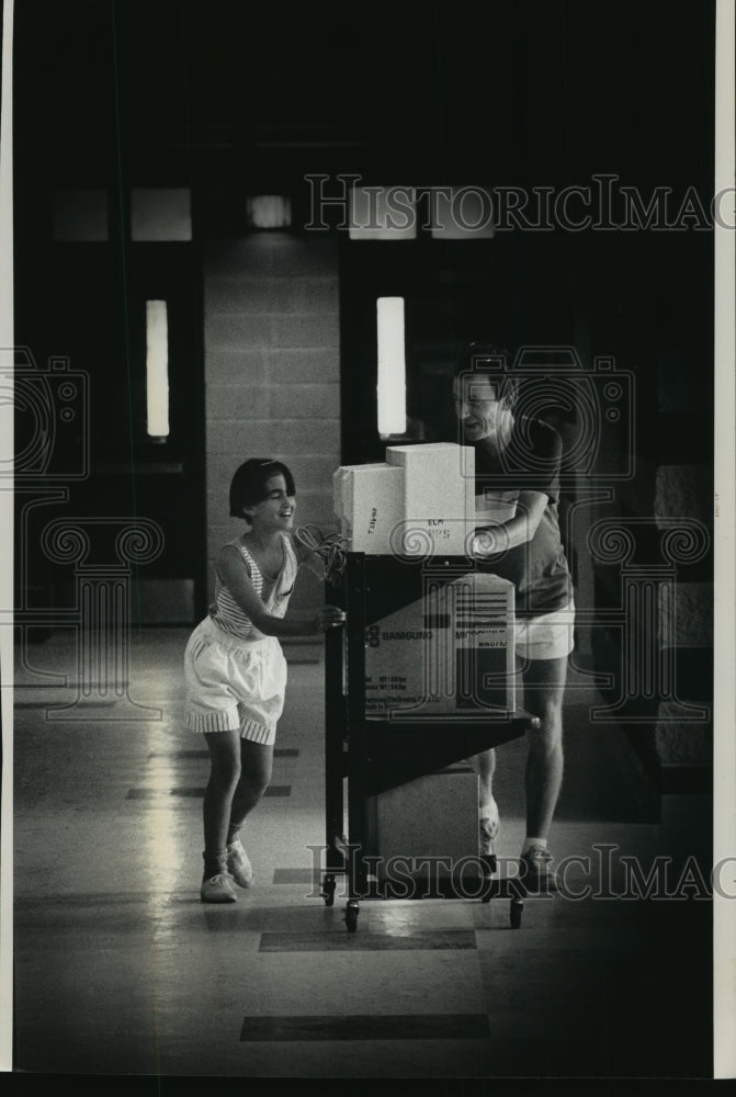 1991 Press Photo Elm Elementary School, daughter and father move equipment. - Historic Images
