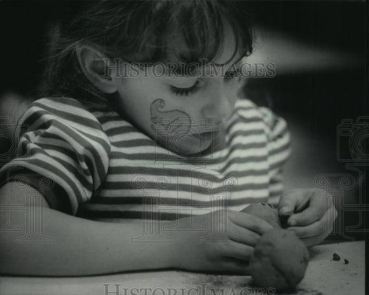 1984 Shama Shelton molds a dinosaur out of clay at Milwaukee Museum - Historic Images
