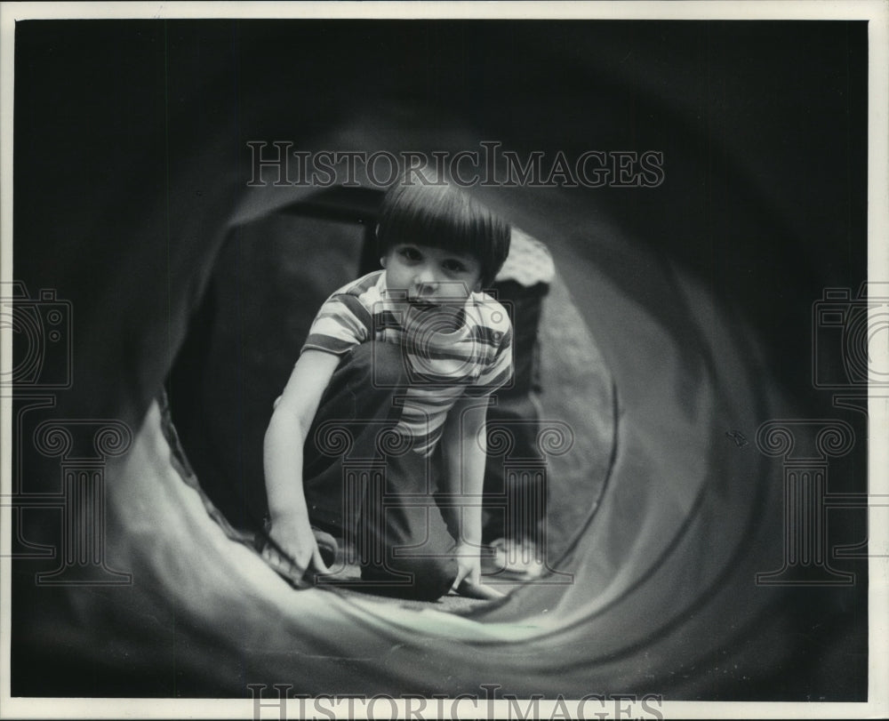 1984 David Faucalt peers into tunnel at Milwaukee Museum - Historic Images