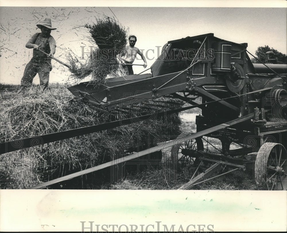 1983 Press Photo Two men at the Old Muskego Settlement Center threshing grain - Historic Images