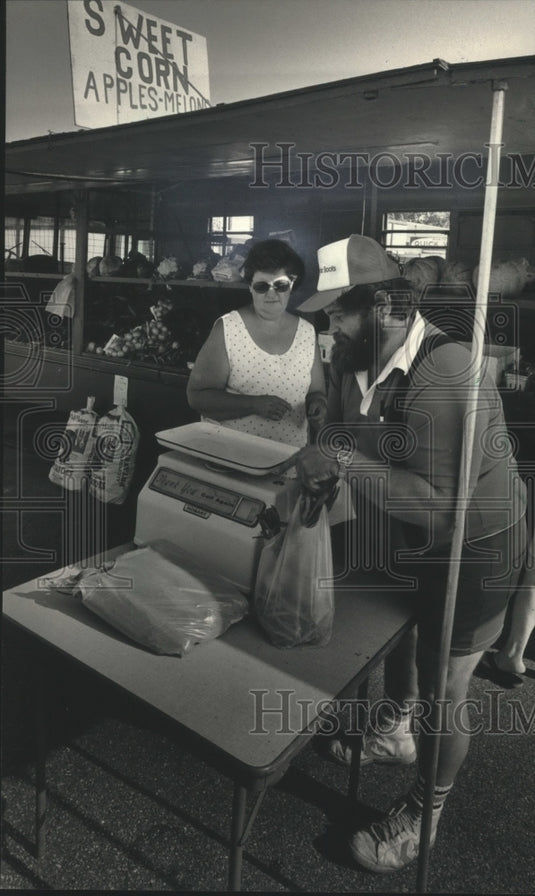 1986 Press Photo Mike Hansen Selling Produce to Barbara Wenzelow in West Bend - Historic Images