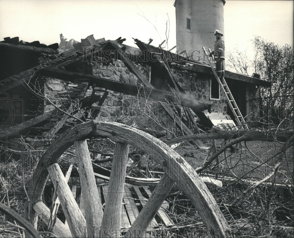 1986 Press Photo Fireman on a ladder views burnt barn in Germantown, Wisconsin - Historic Images