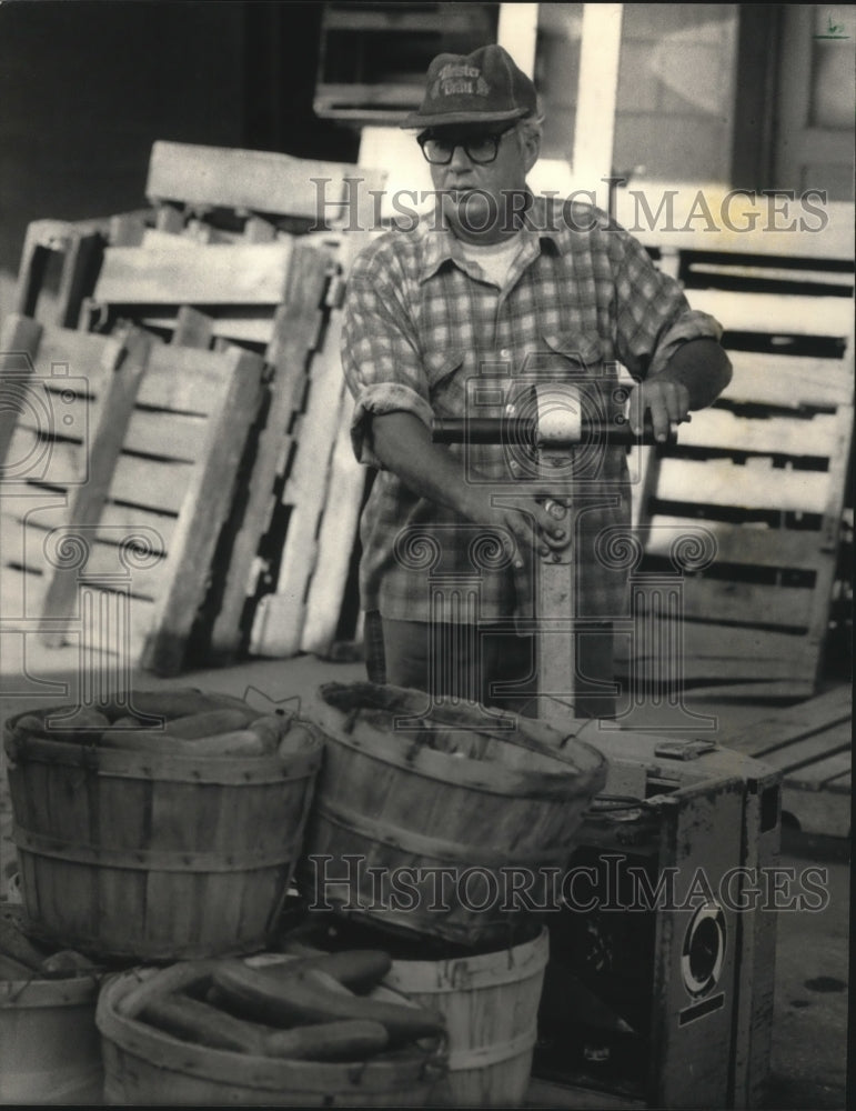 1986 Press Photo Butch Robran Loads Baskets of Cucumbers at Gardens Near Troy - Historic Images