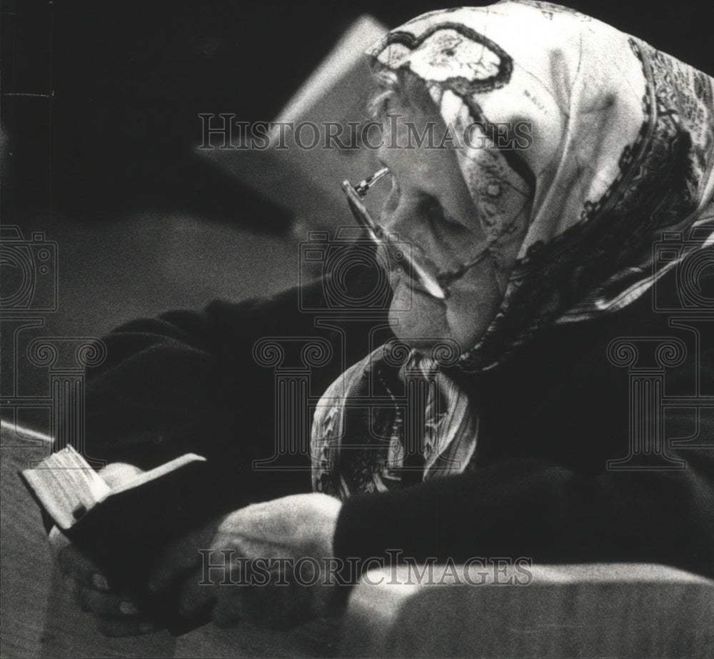 1990 Lithuanian woman praying at mass at Blessed Virgin Mary Church - Historic Images
