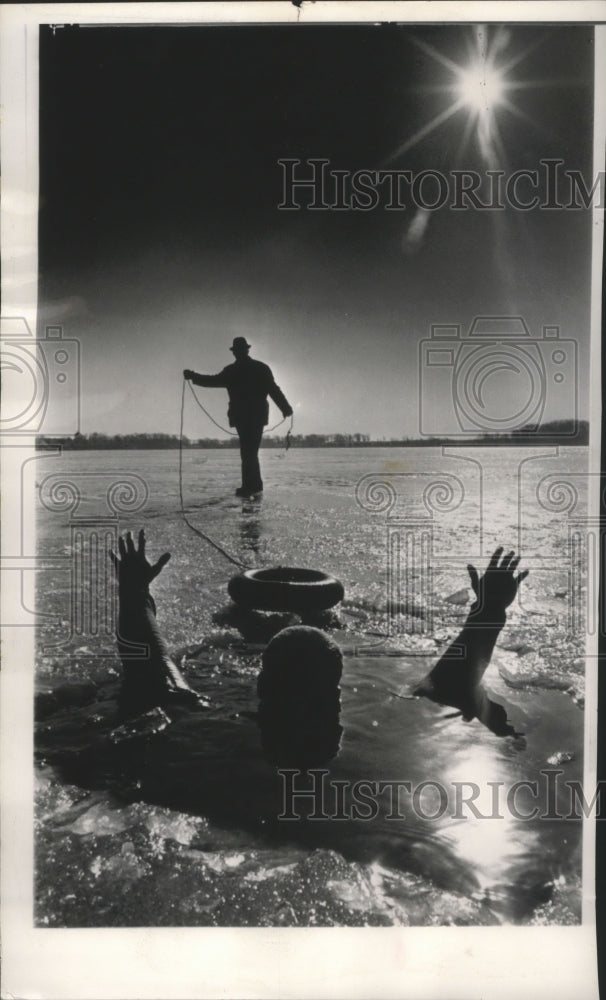 1964 Press Photo A man waves for help in a demonstration of frozen lake rescue - Historic Images