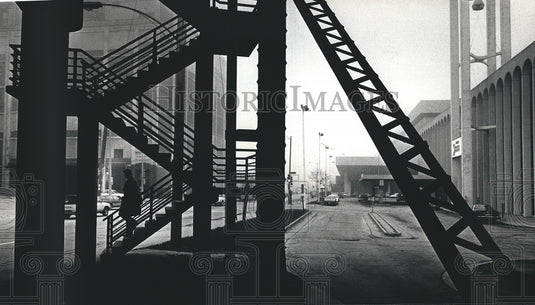 1991 A pedestrian descends stairs in the fog - Historic Images