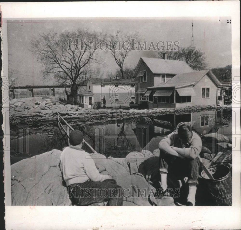 1965 Press Photo volunteers rest while keeping watch over sandbag dike, Dubuque - Historic Images