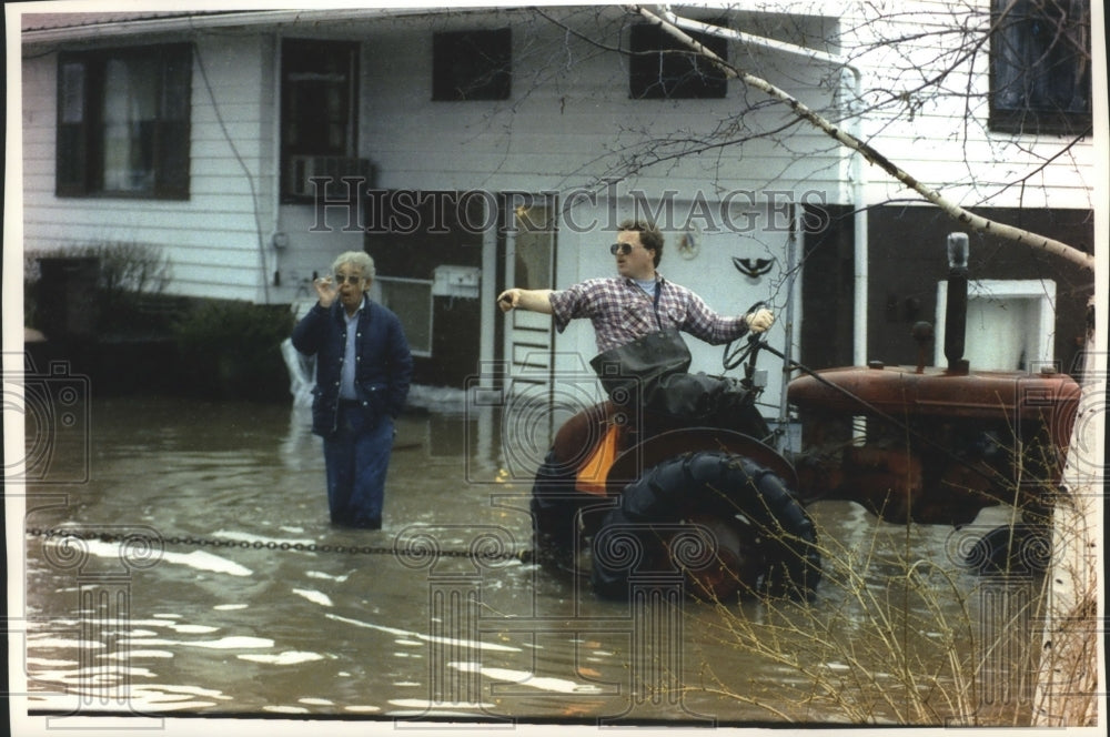 1993 Scott Umland guides his tractor out after flooding in Wisconsin - Historic Images