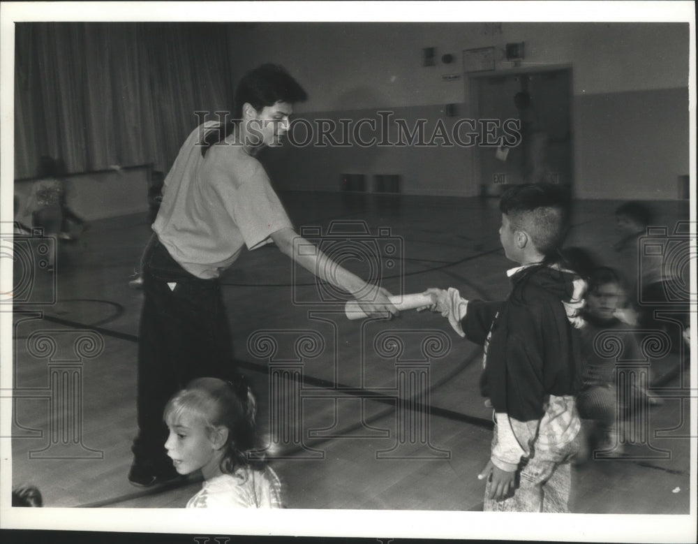 1992 Press Photo Luis Santiago plays a game with students at Longfellow School - Historic Images