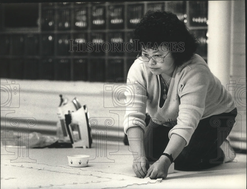 1989 Press Photo Nao Lee Xiong stretches and irons for Linens Limited - Historic Images