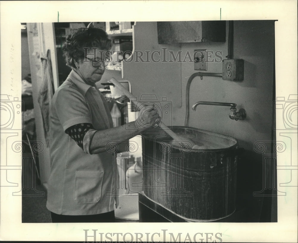 1986 Press Photo Monica Anderson washes fabric in laundry room at Linens Limited - Historic Images